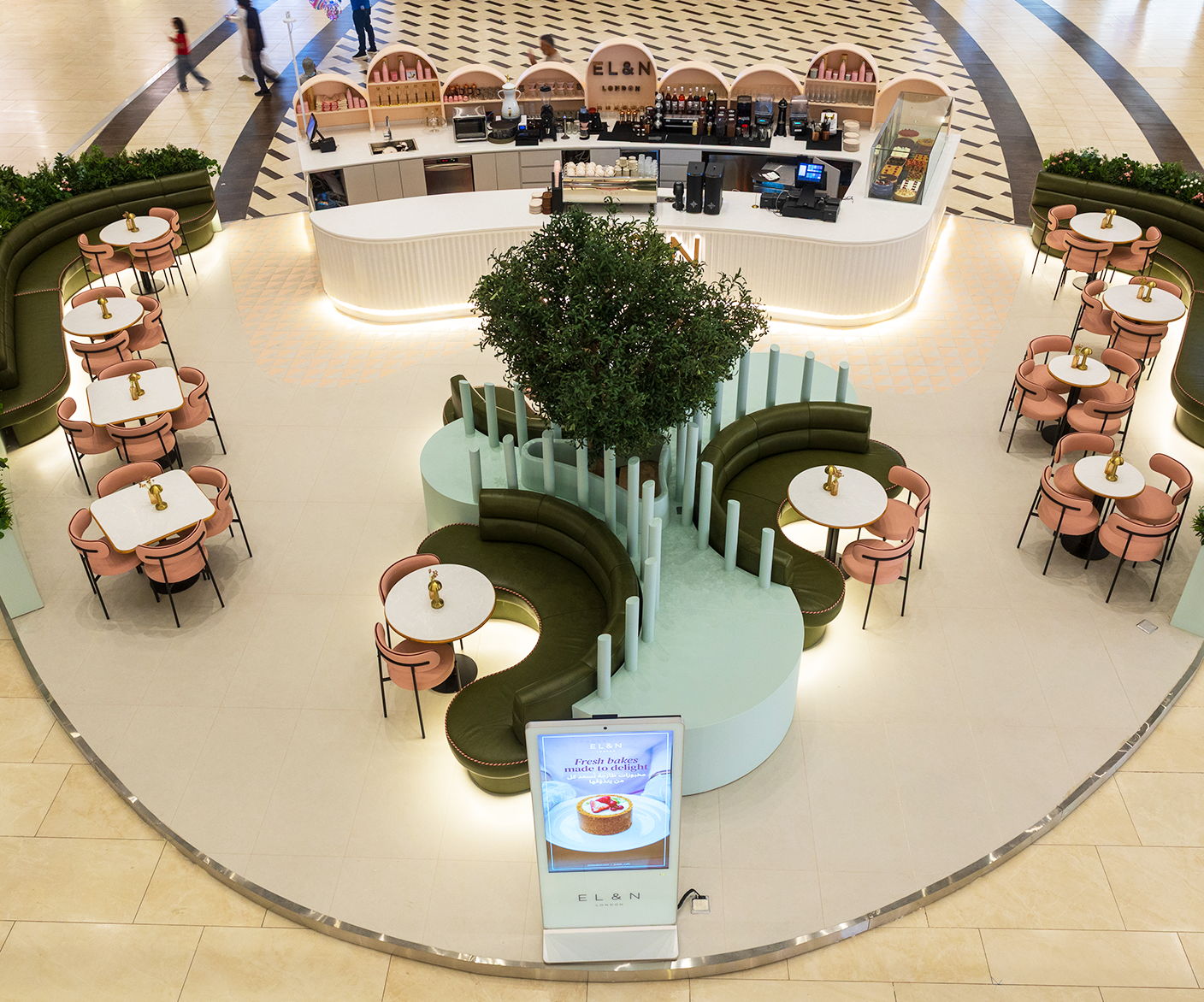 A modern café interior with seating and greenery.