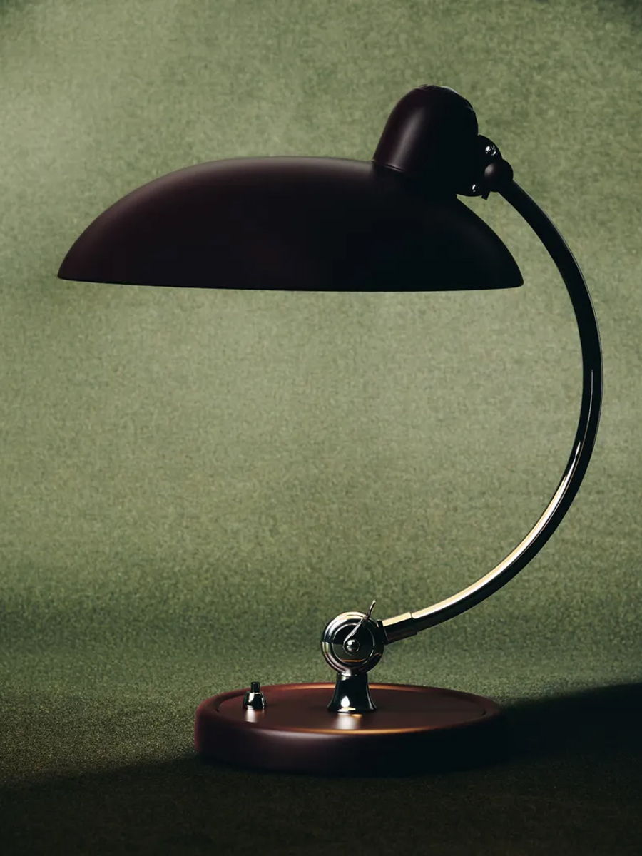 A sleek, modern desk lamp with a curved arm and dark shade.