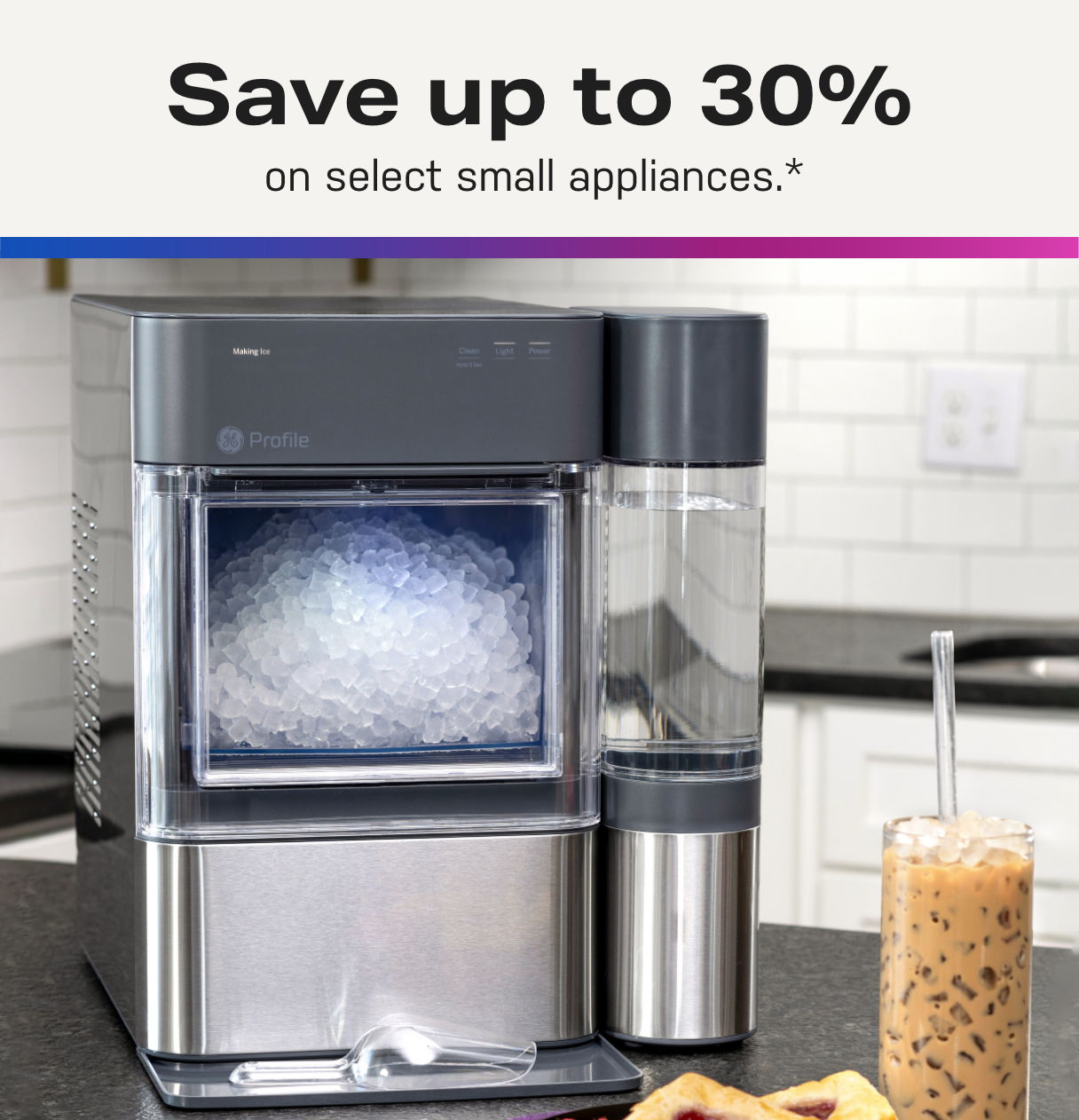 Ice maker appliance with a glass of iced coffee beside it.