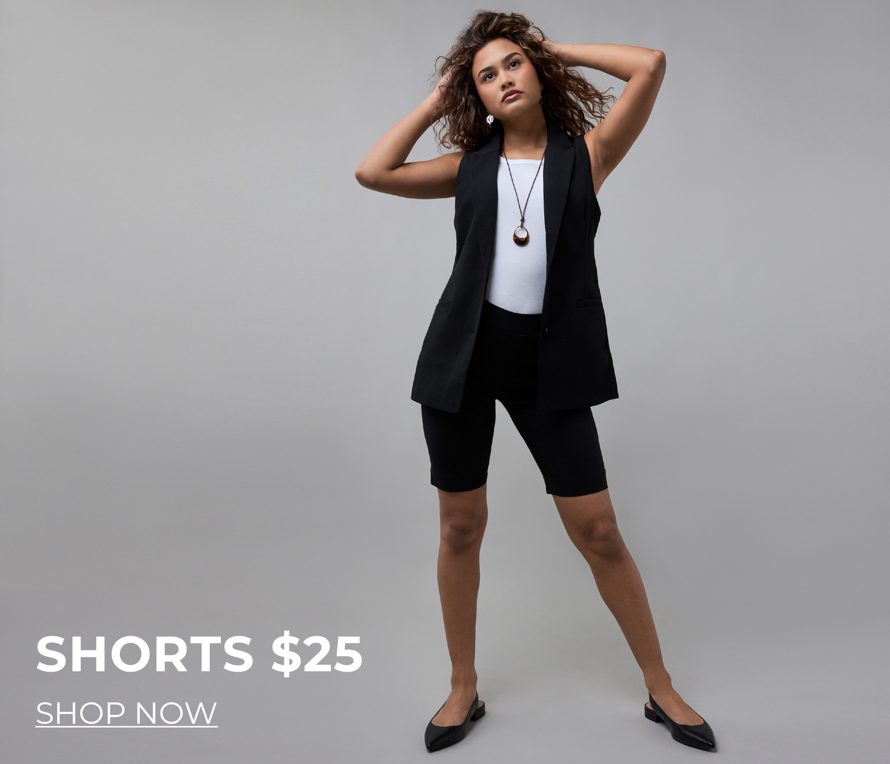 Model wearing black shorts and a vest, promoting a sale.