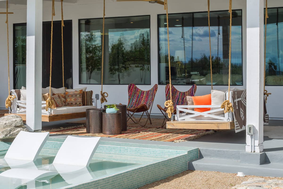 Boxhill modern outdoor design embraces the indoor-outdoor connection with plush hanging chairs, throw pillows, and outdoor rugs