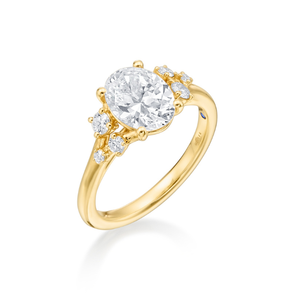 Gold engagement ring with an oval diamond and side stones.