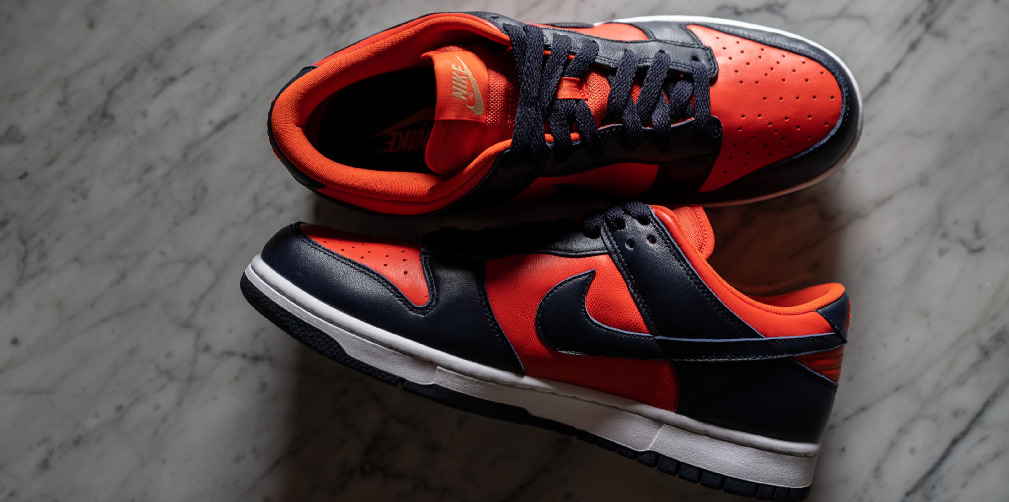 A pair of red and black sneakers, resting on a marble surface