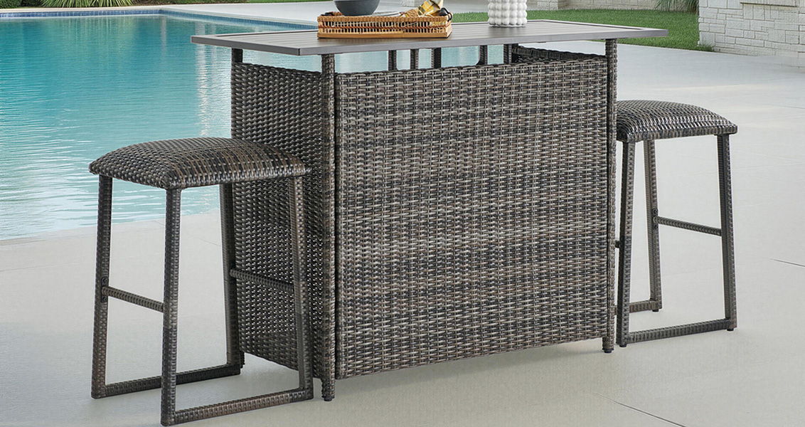 Outdoor bar table with two stools beside a swimming pool.