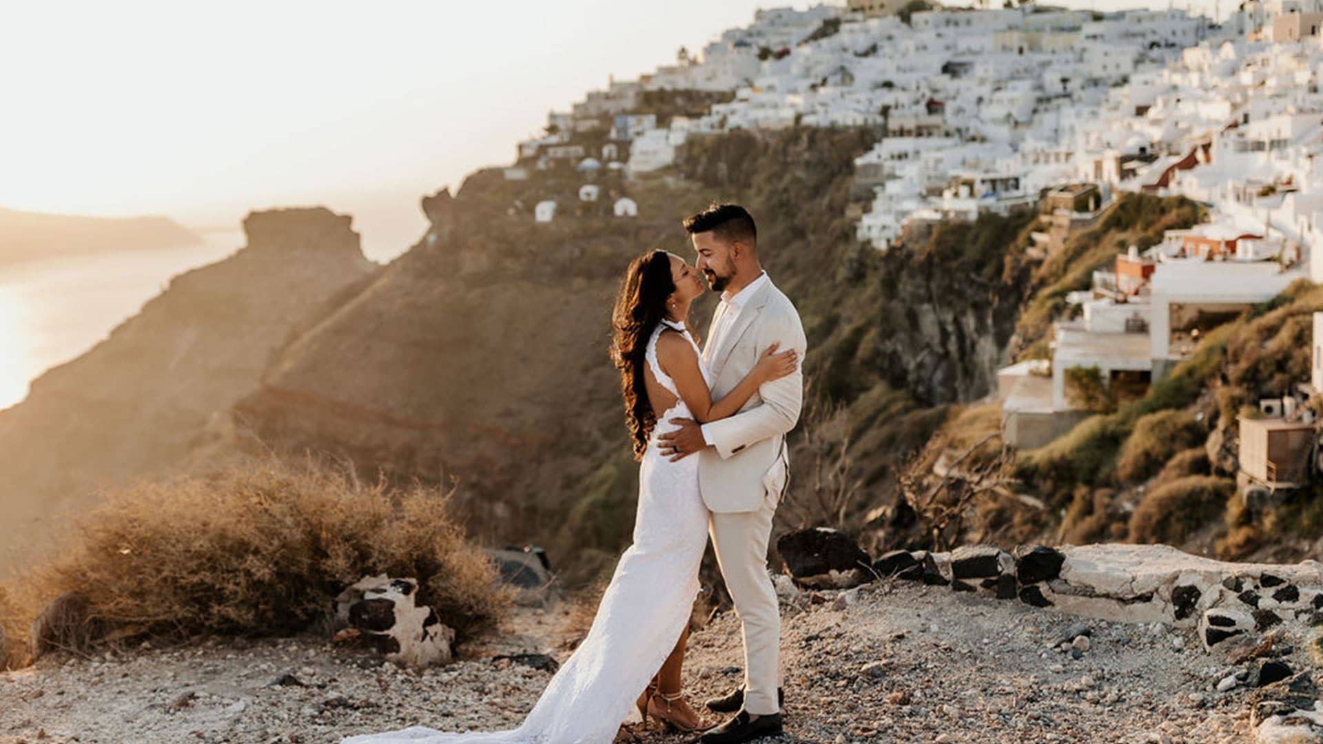 Bride and groom hugging overlooking Santorini houses