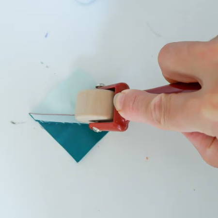Press the seam with a seam roller on a small quilt unit
