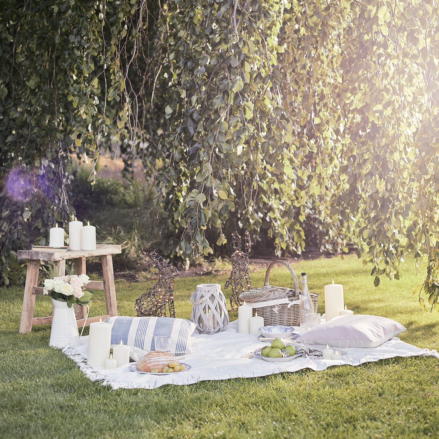 Garden picnic setting with rattan figures and candles displayed