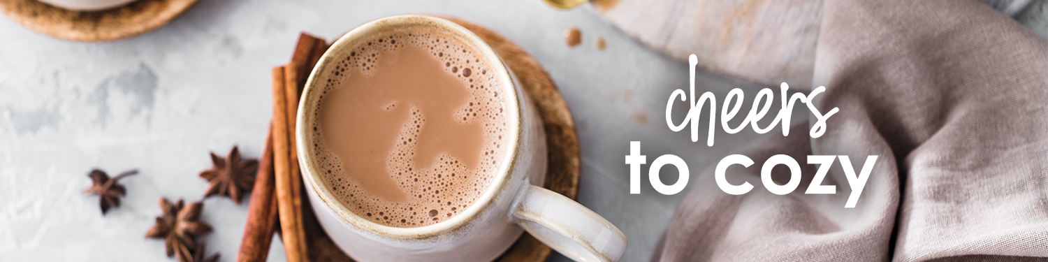 cheers to cozy. Cup of Oh My Chai mug with cinnamon sticks.