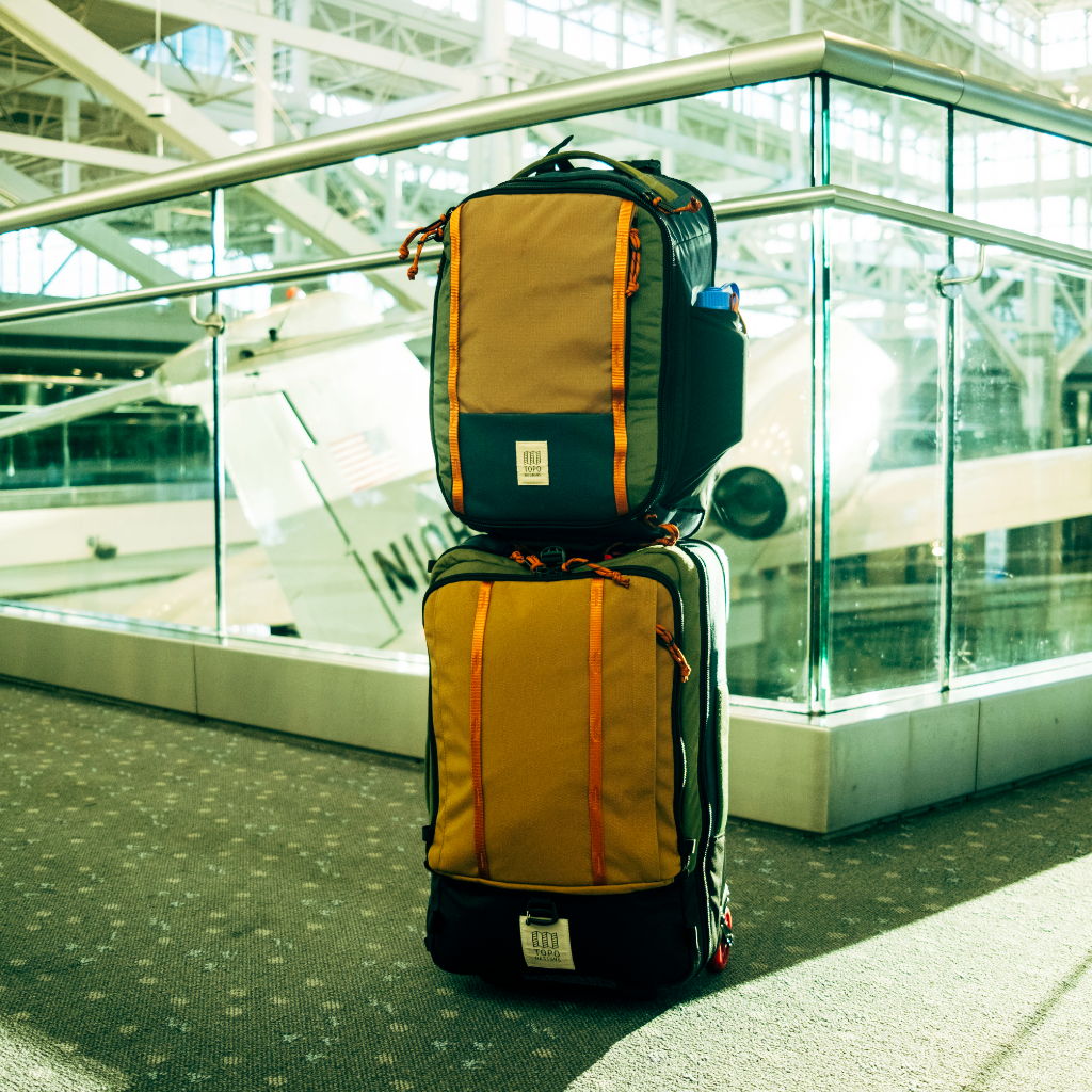 Two stacked travel bags in an airport terminal.