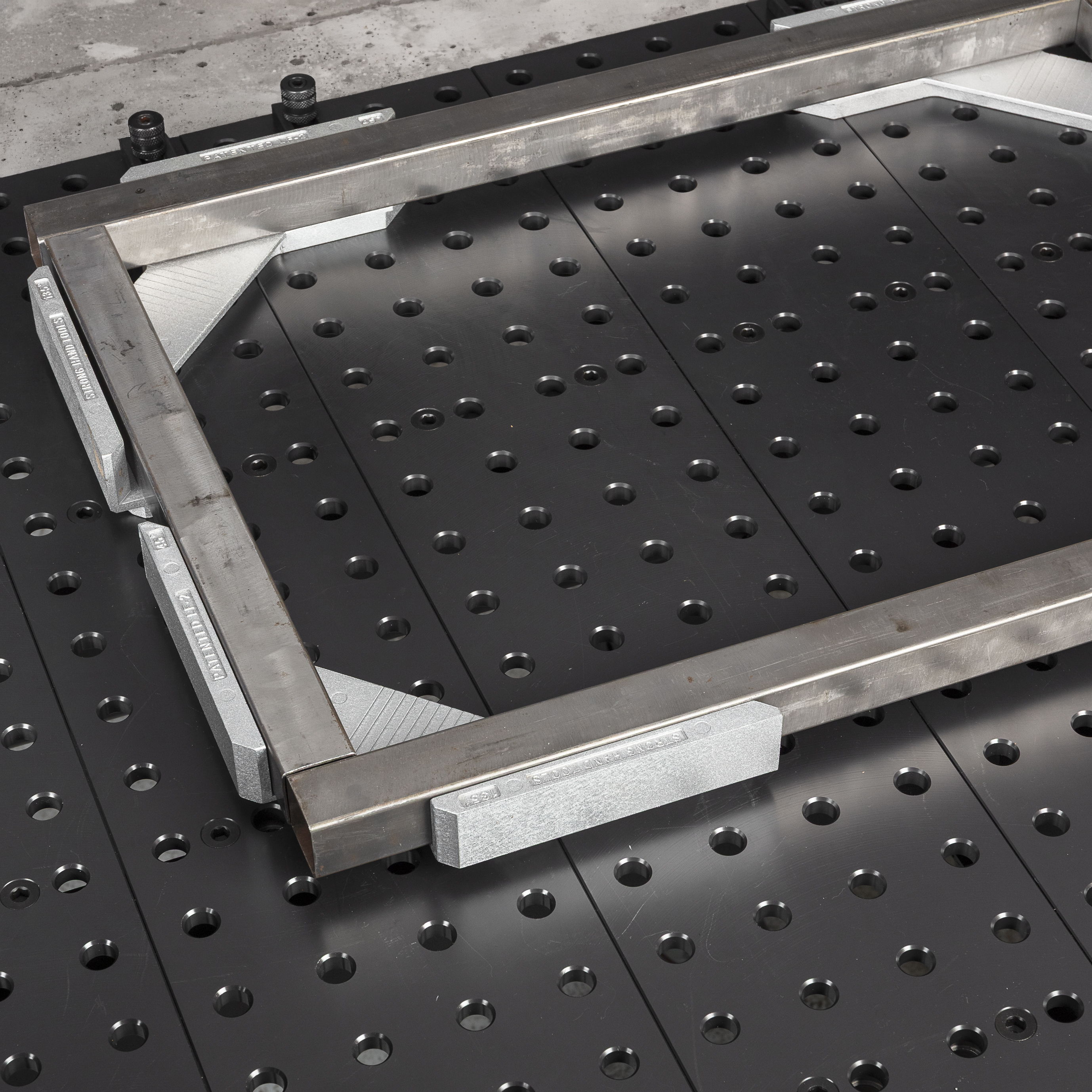 Metal frame on a black perforated surface.
