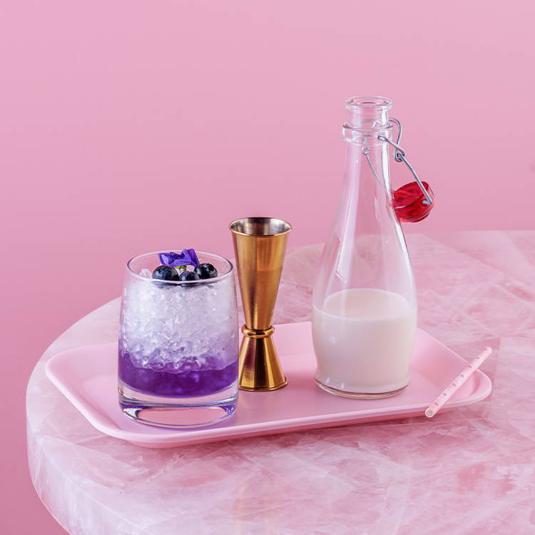 Blue Sapphire Iced Latte drink on tray against pink background