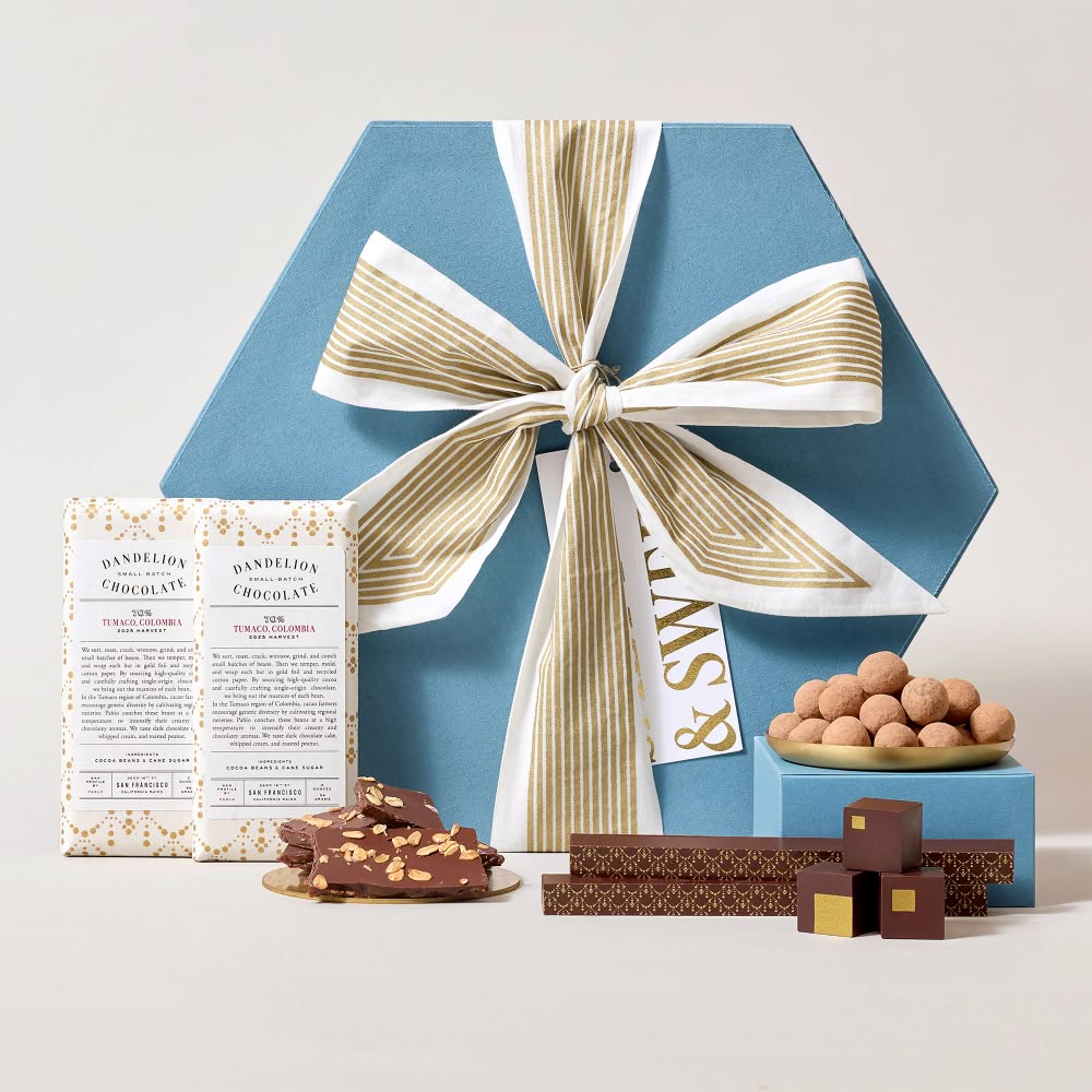 Gift box with a ribbon, chocolates, and snacks arranged aesthetically.
