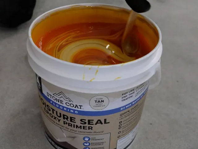 Mixing and applying Moisture Seal Epoxy Primer to the floor, ensuring a strong bond to the concrete slab.
