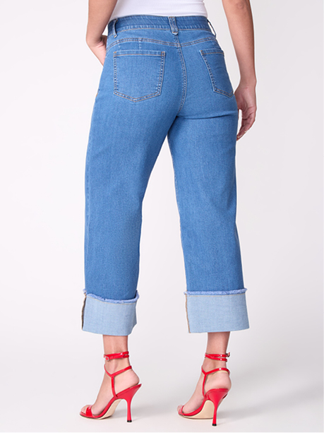 Model wearing light blue cropped jeans with rolled cuffs and red high heels.