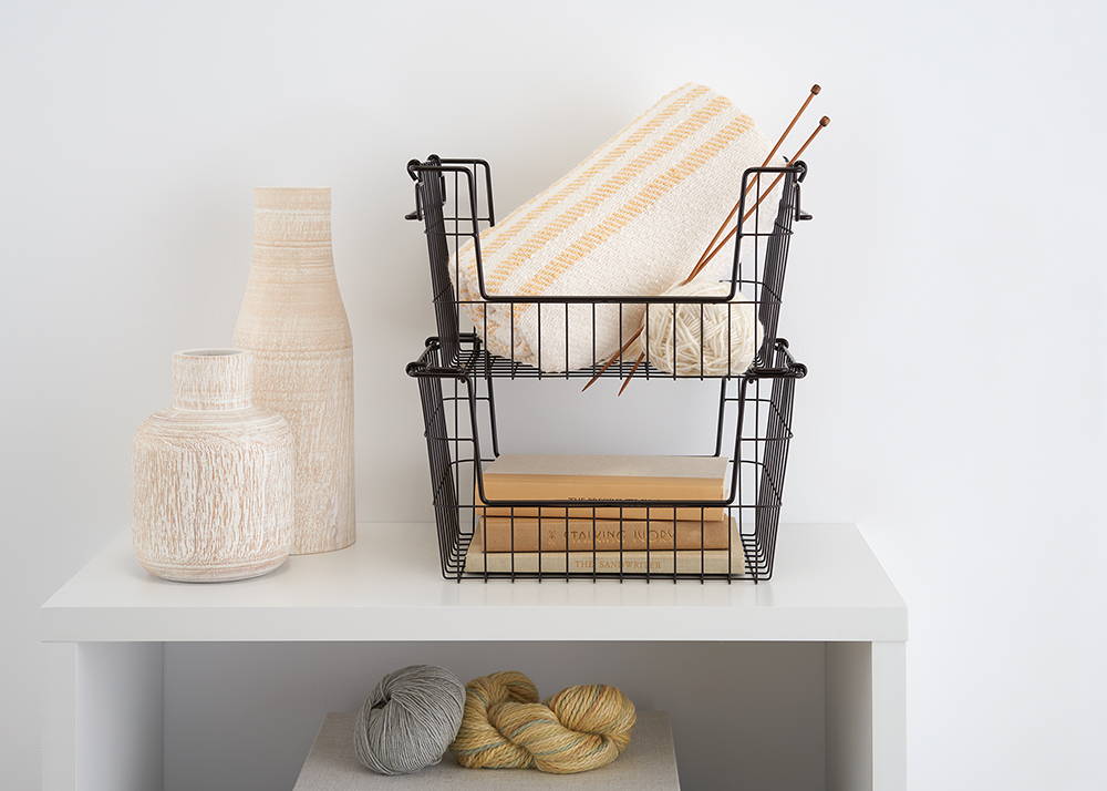 Stackable wire baskets on shelf with items inside