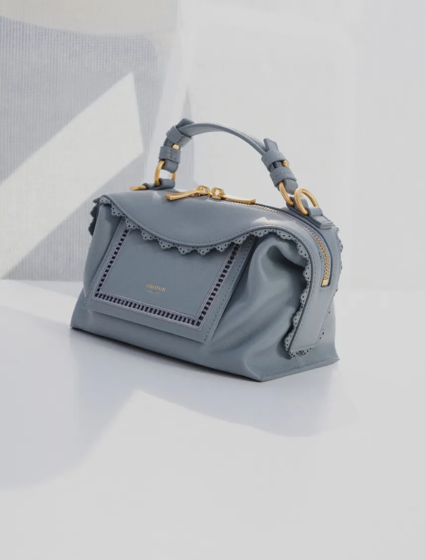 A stylish gray handbag with a structured design and gold accents.