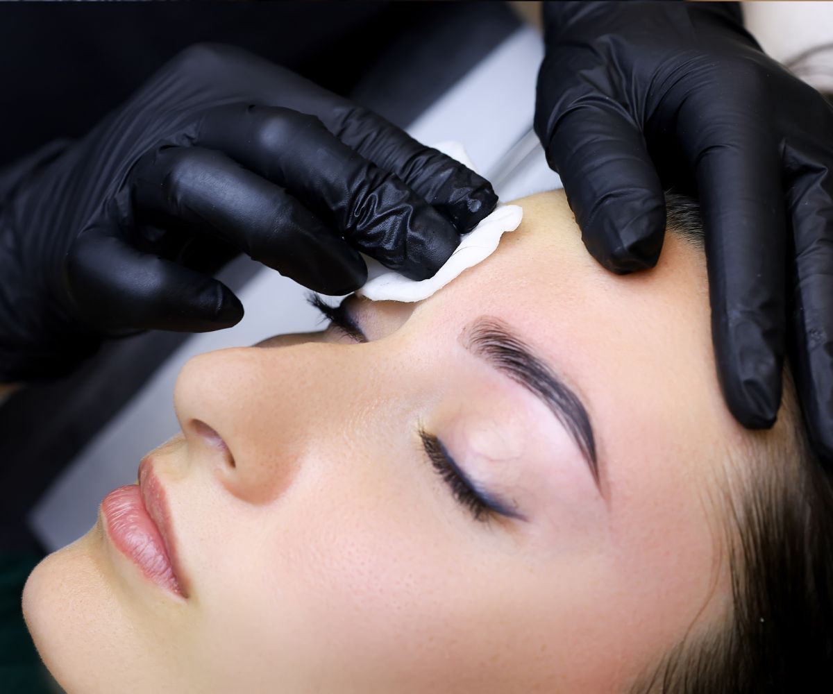 Person having their eyebrows cleaned with a cotton pod.