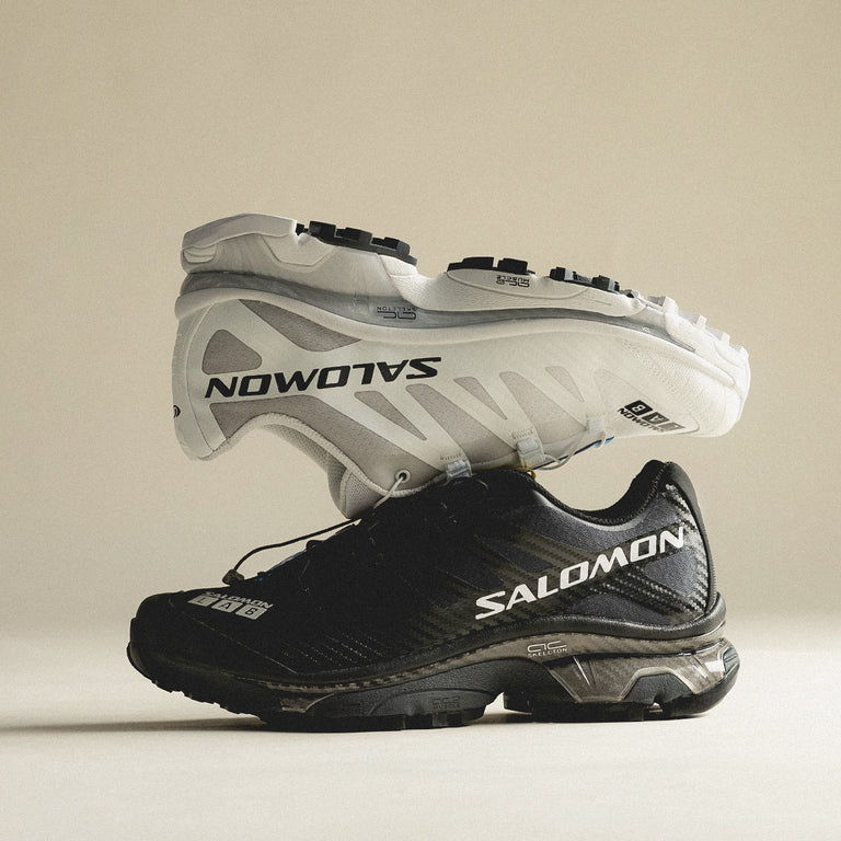 A pair of Salomon running shoes, one white and one black.