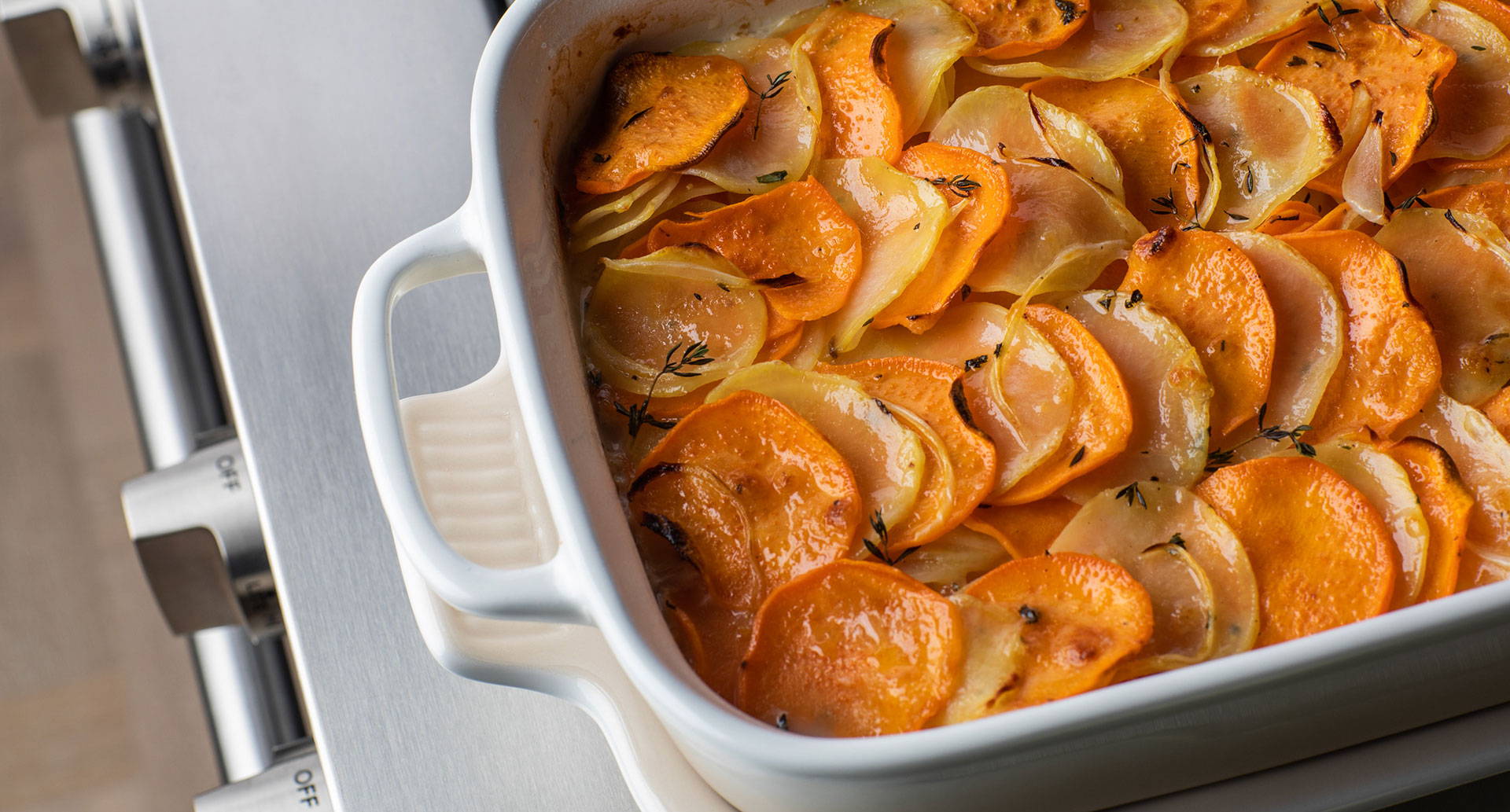 Sliced sweet potatoes and Yukon gold potatoes in a casserole dish