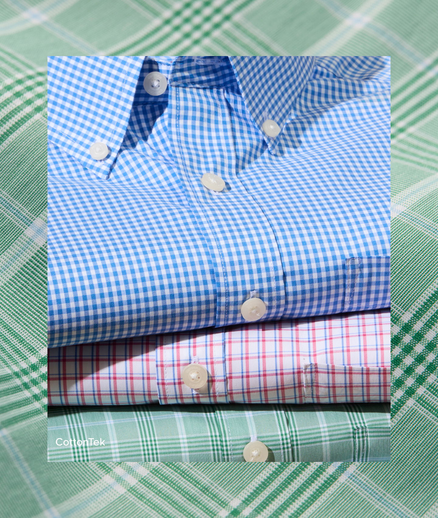 Three collared dress shirts stacked on a patterned background.