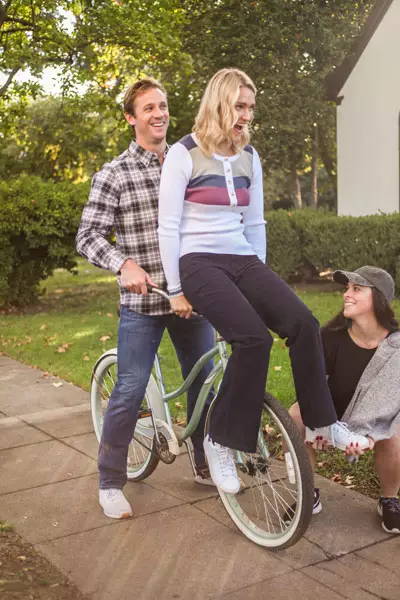 Male and female models on bike about to fall over.