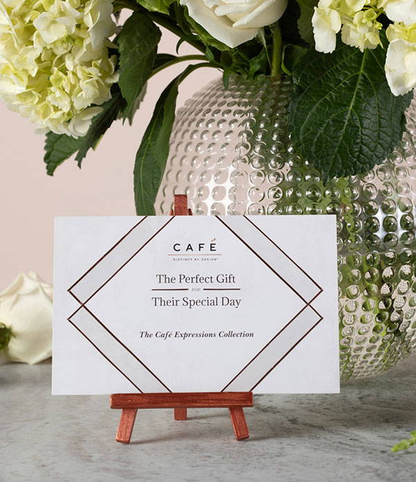 Card on stand in front of flowers that reads The Perfect Gift for Their Special Day
