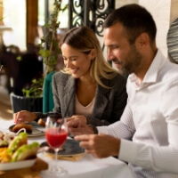 Couple enjoying a meal together at a restaurant with drinks.