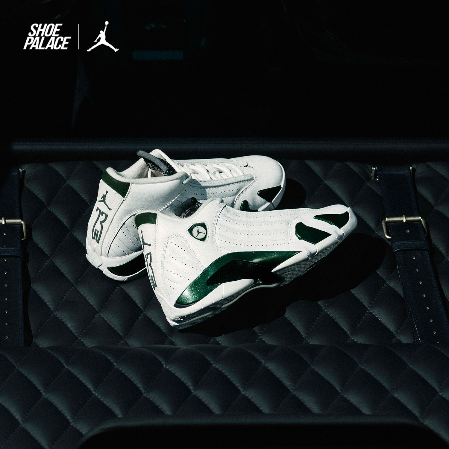 White and green basketball shoes on a textured black surface.