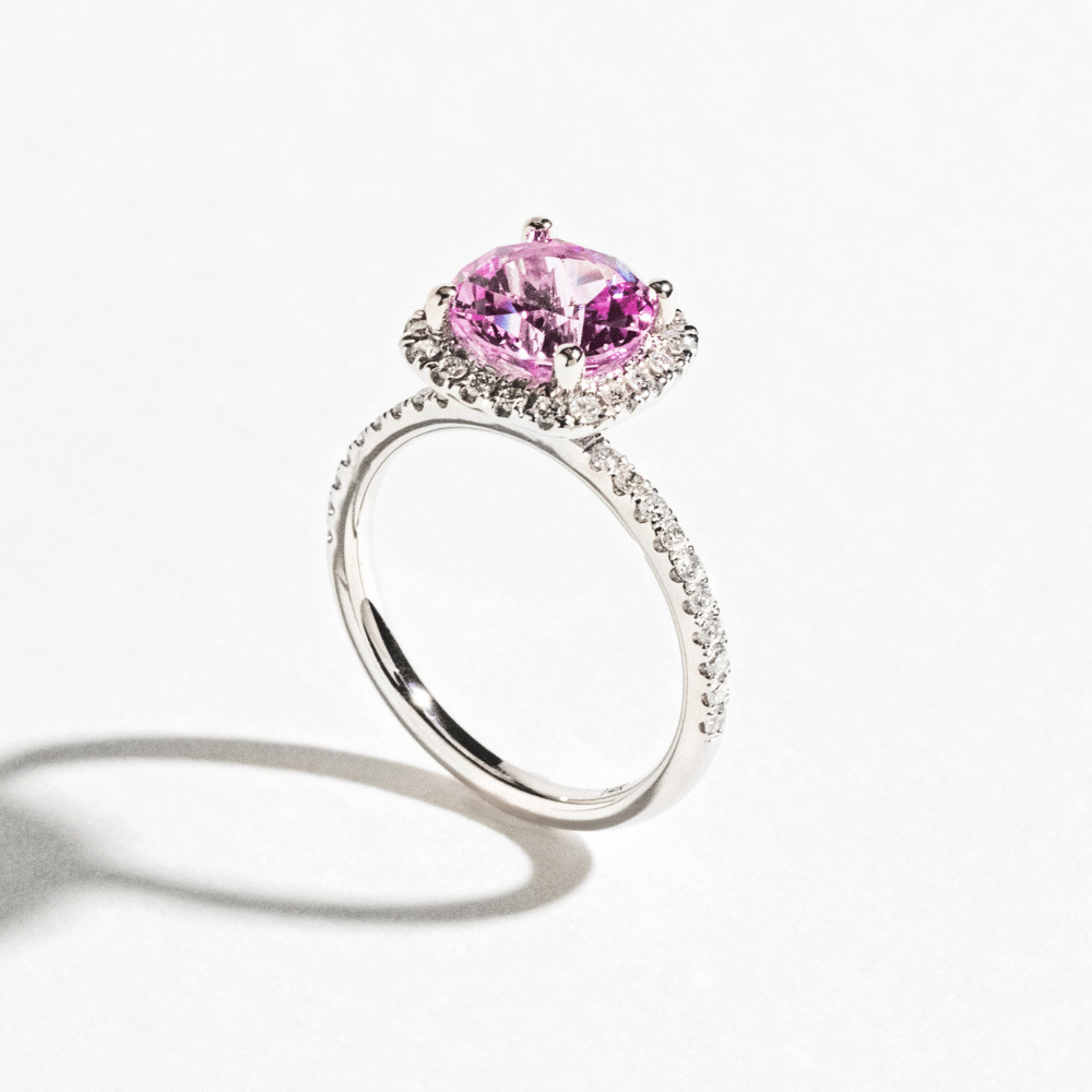 2ct cushion cut pink sapphire engagement ring with diamond halo and accented band in white gold