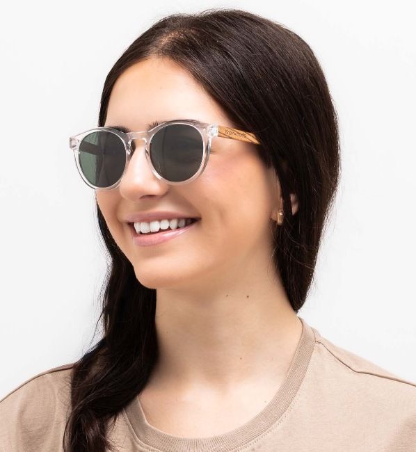 woman wearing Funk, round sunglasses with green lenses, on a white background
