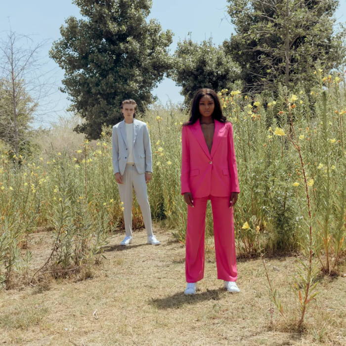 male and female model wearing suits wearing white adidas stan smith shoes in flower field