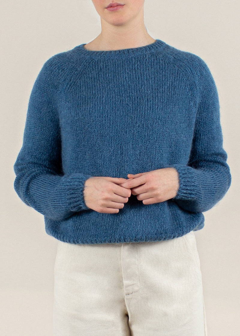 A model wearing a teal boxy sweater