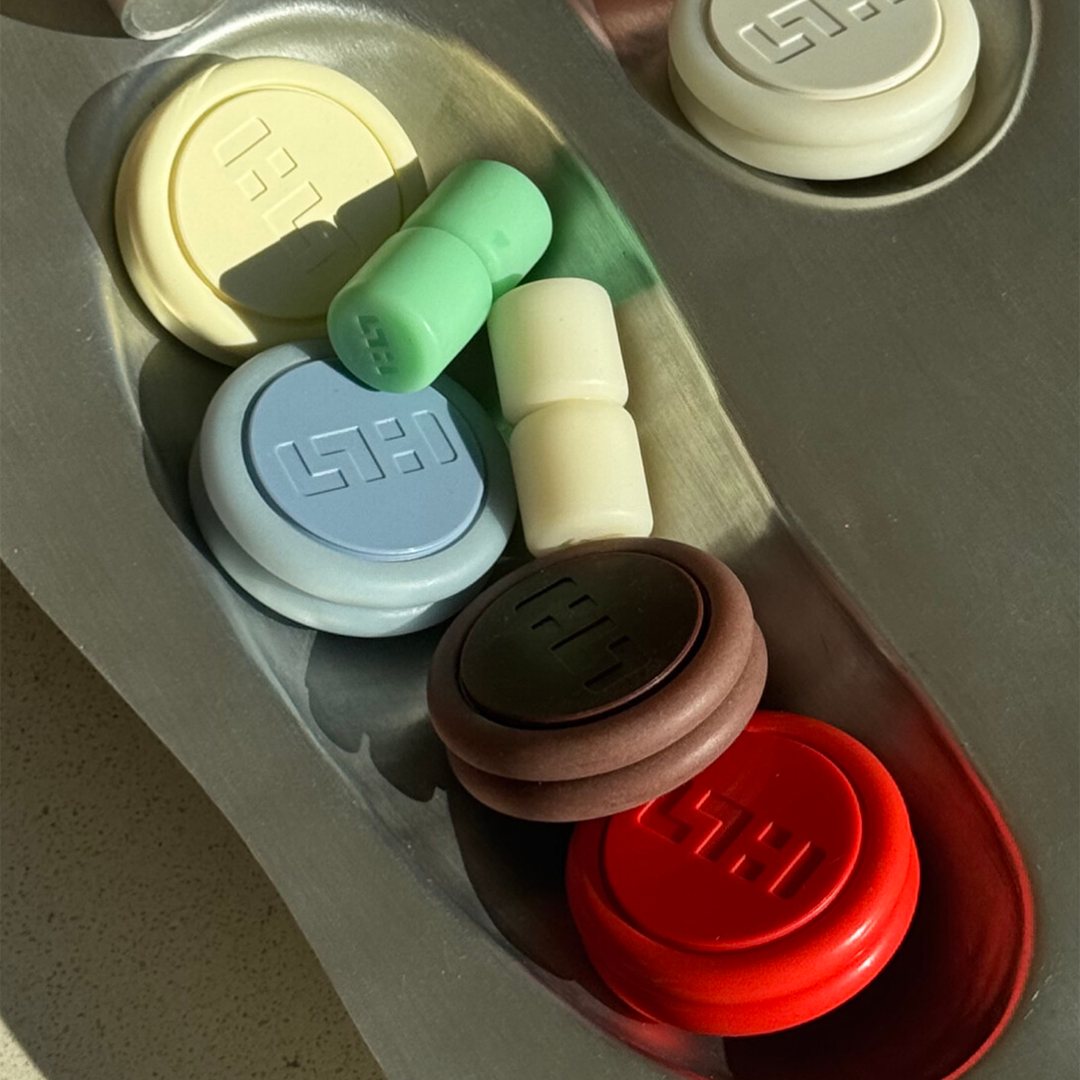 Colorful tokens arranged in a tray with various shapes and sizes.