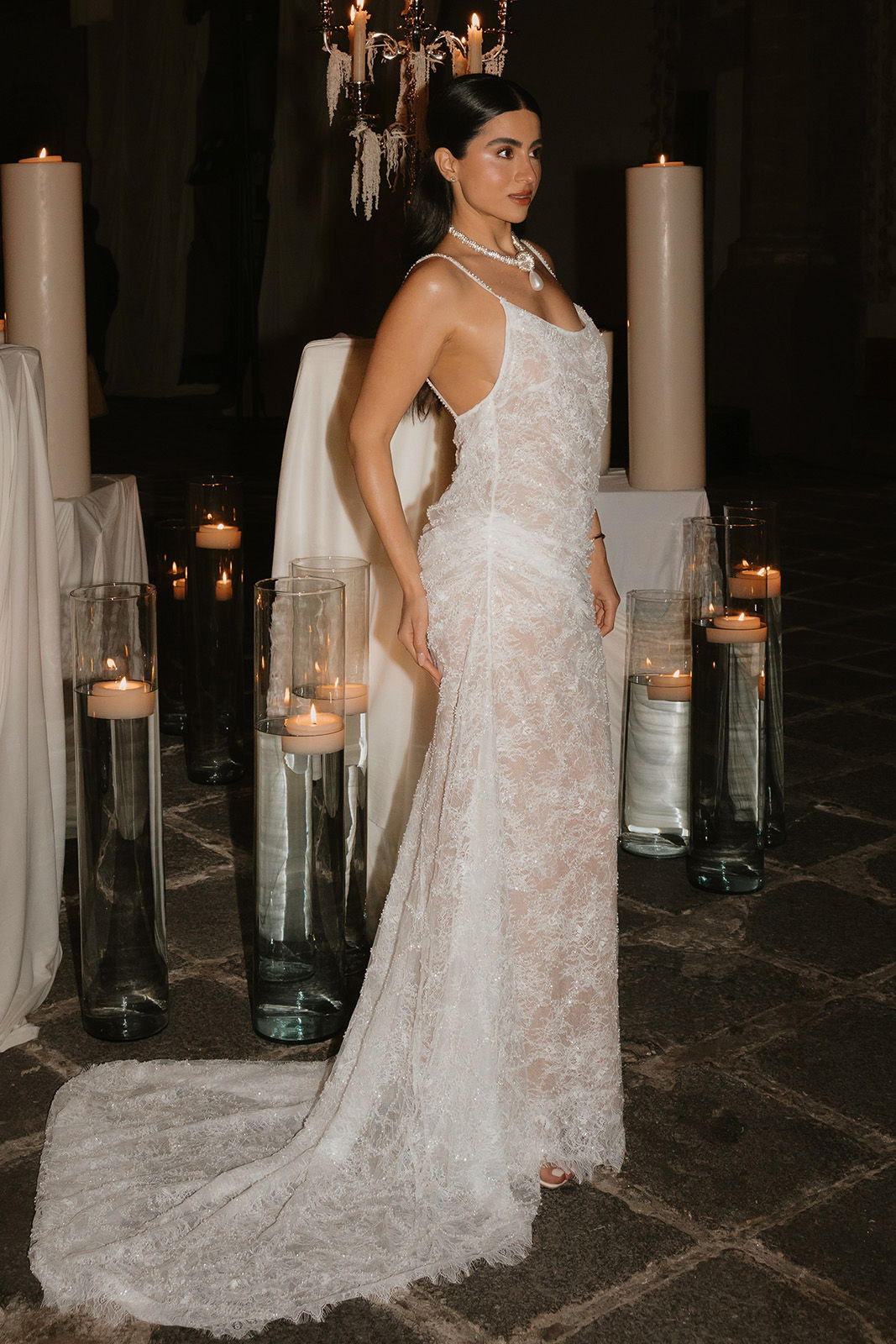 Bride in front of a display of candles at her wedding reception in a sequin sheer wedding dress