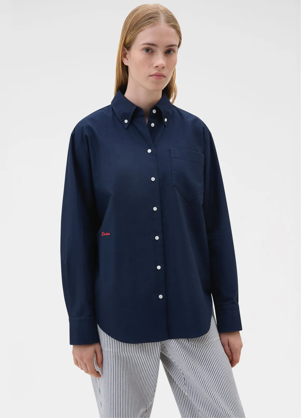 Woman wearing a navy blue button-up shirt with a pocket.