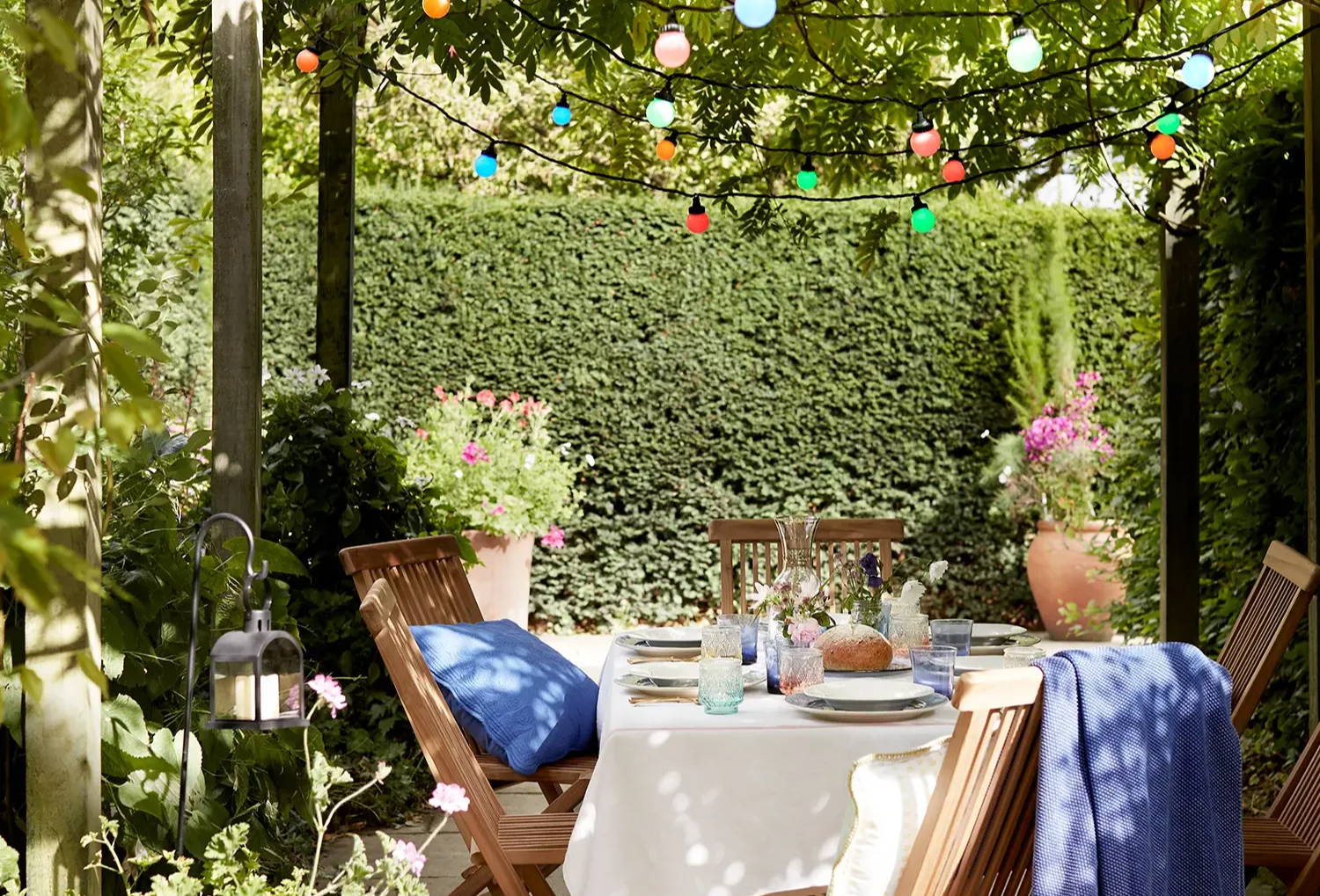 Multi coloured festoons over an outdoor dining area.