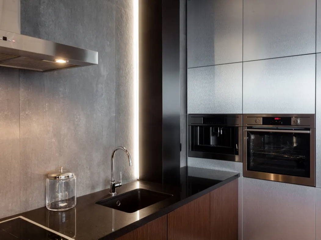 Modern kitchen with concrete wall and recessed lighting