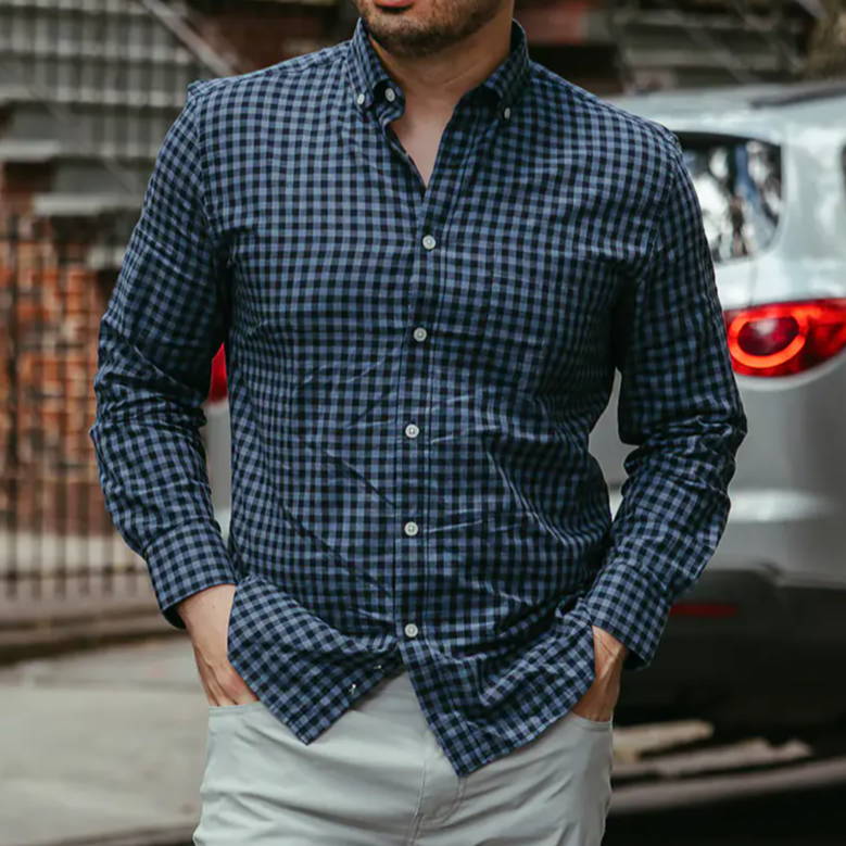 Man walking on the street, wearing a blue shirt and white pants.