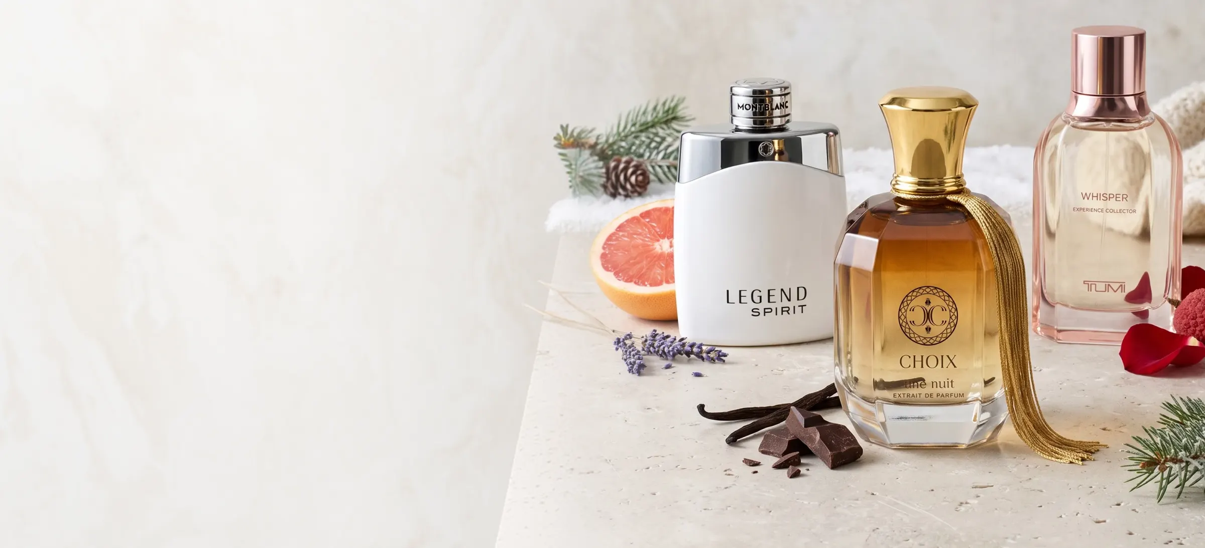 Montblanc Legend Spirit, Choix Une Nuit and TUMI Whisper on a marble table with grapefruit, chocolate and pine