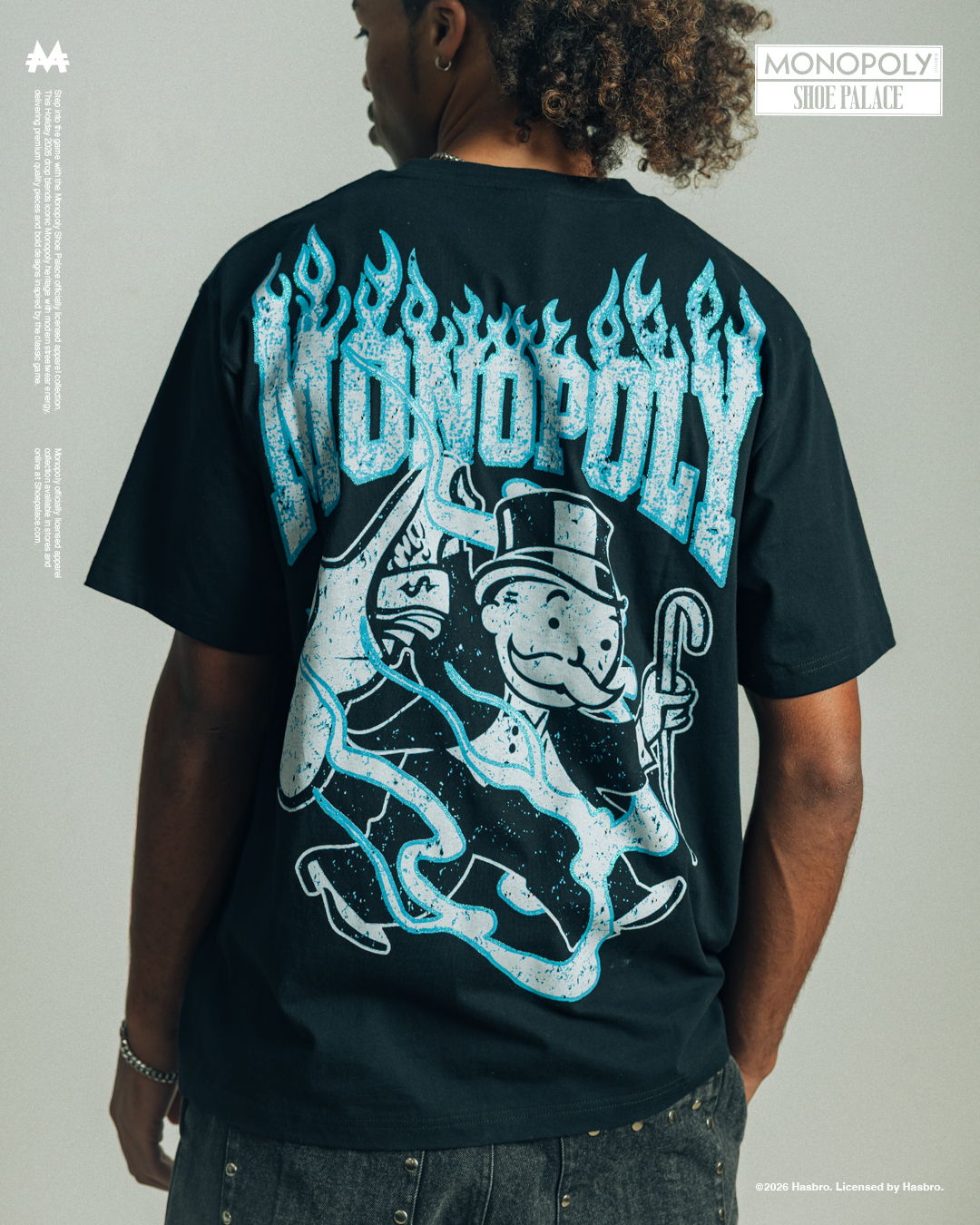 Person wearing a black t-shirt with a Monopoly graphic and flames design.