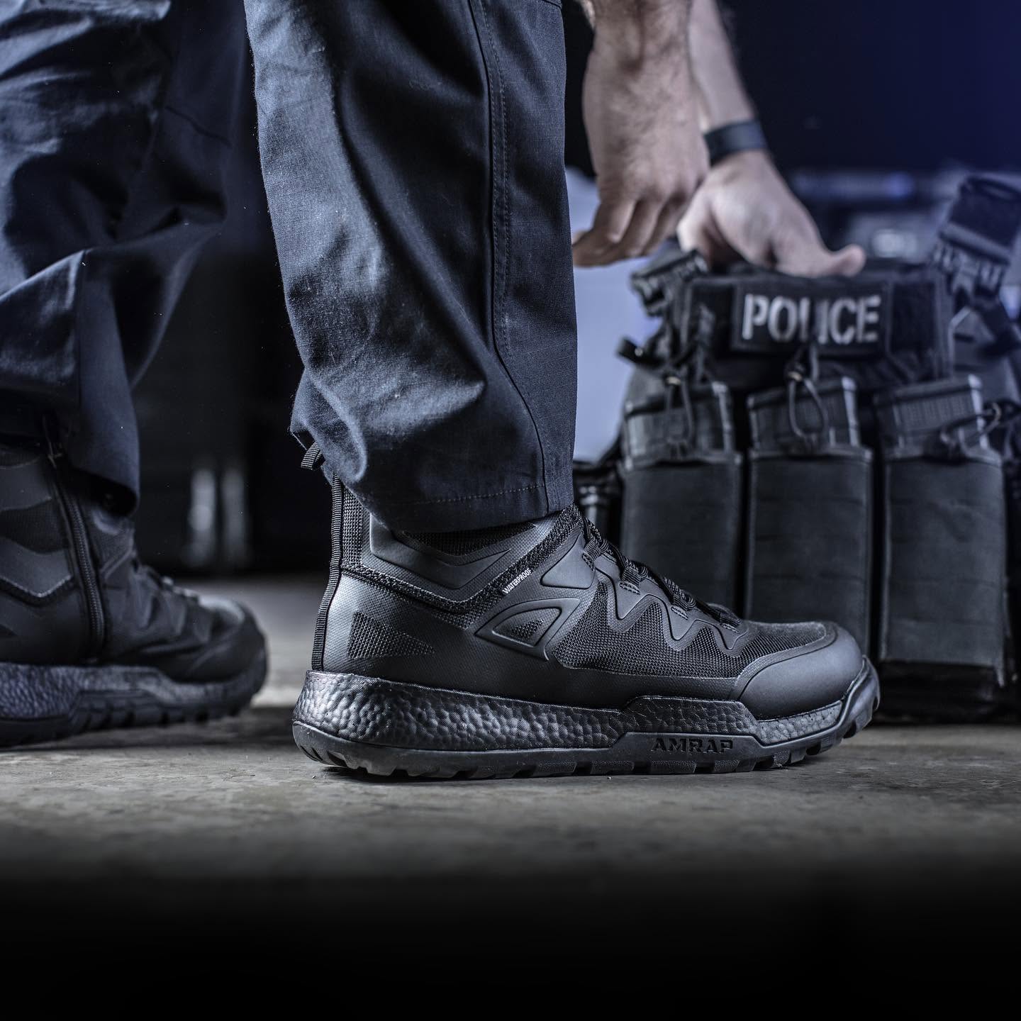 A police officer's shoes next to a tactical gear bag.