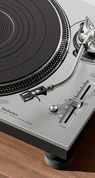 A close-up of a Technics turntable on a wooden surface.
