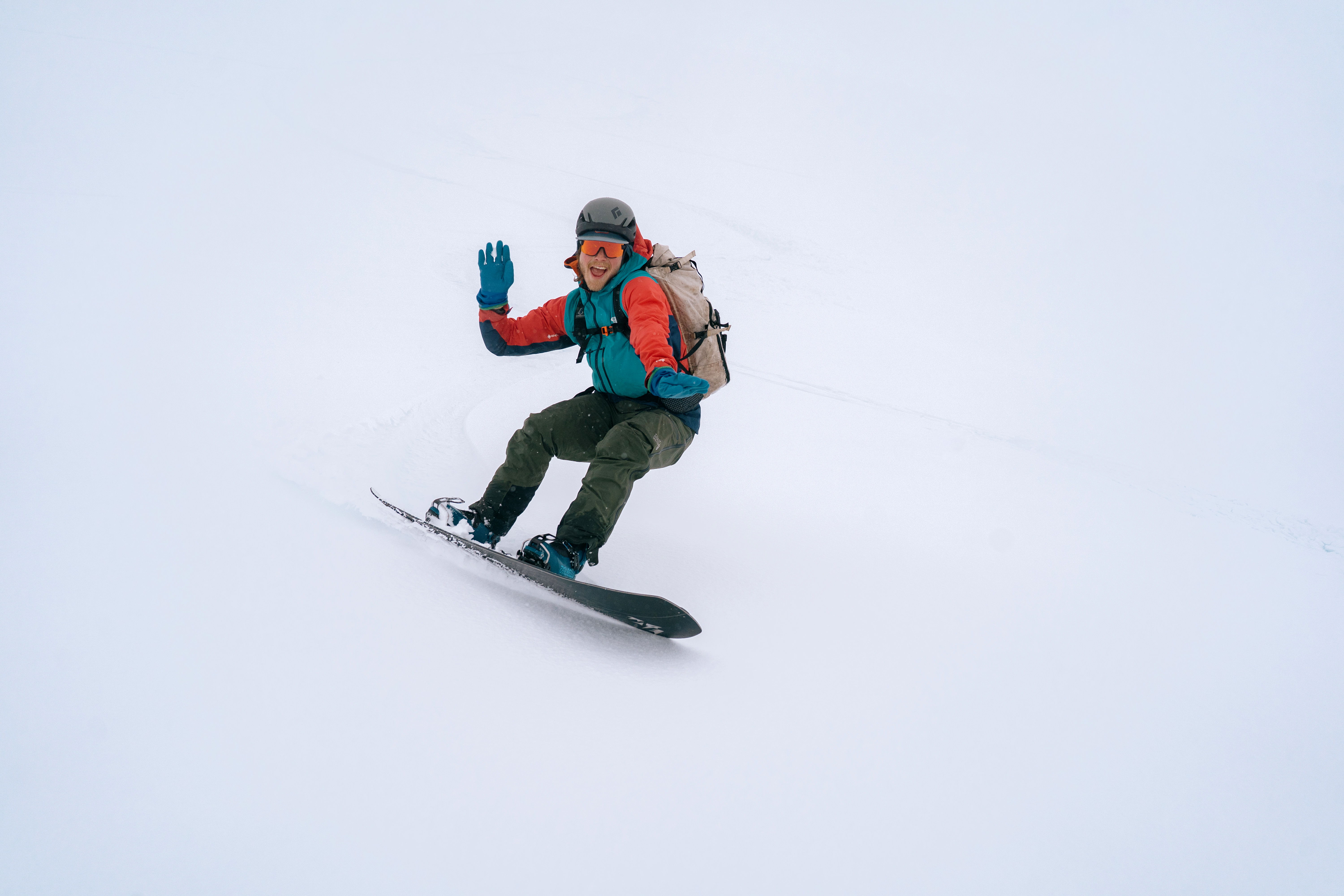 A person snowboarding on a snowy slope, wearing colorful winter gear.