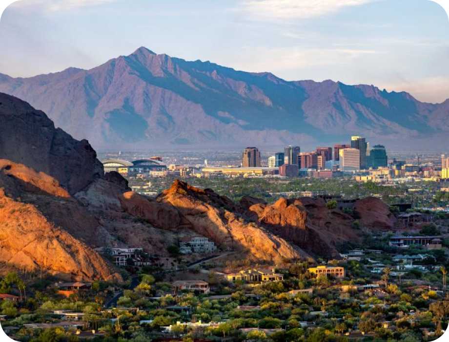 Scenic view of mountains and a city skyline at sunrise.