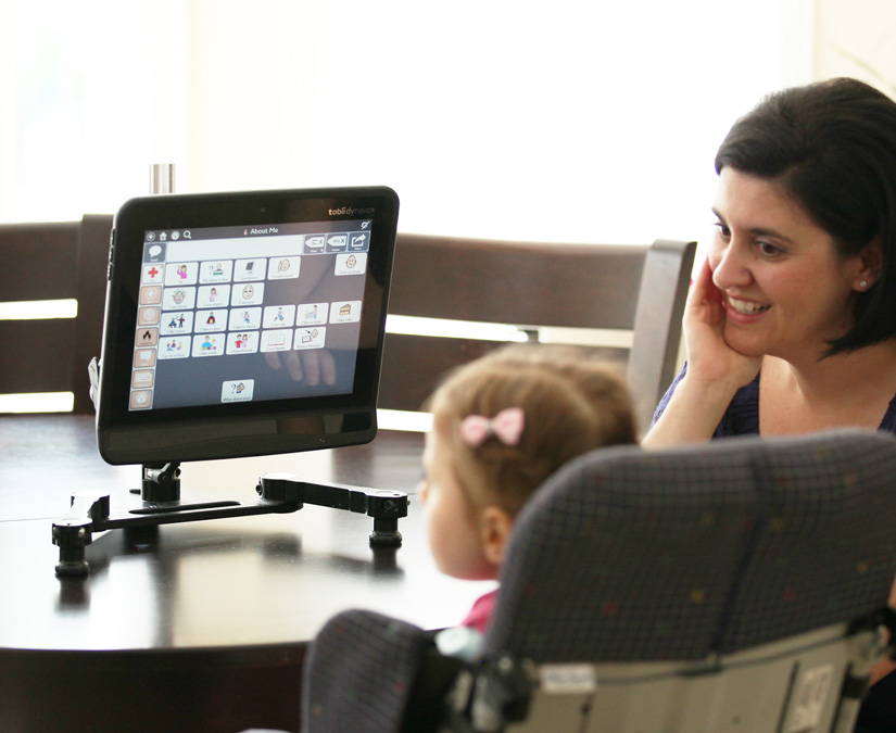 Ein junges Mädchen mit Rett-Syndrom nutzt eine Tobii Dynavox UK-App und unterstützende Technologie, um mit ihrer Mutter zu kommunizieren.