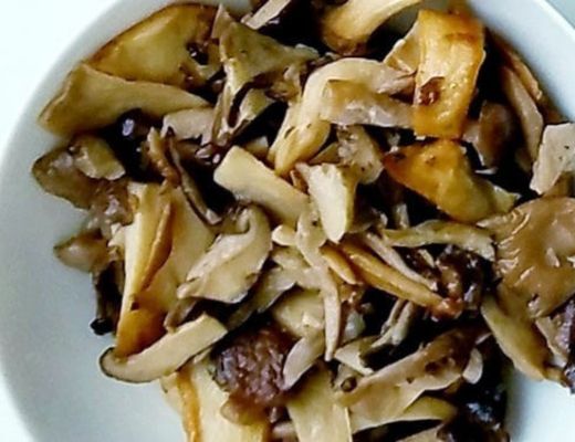 Sautéed mushrooms and vegetables in a white bowl.