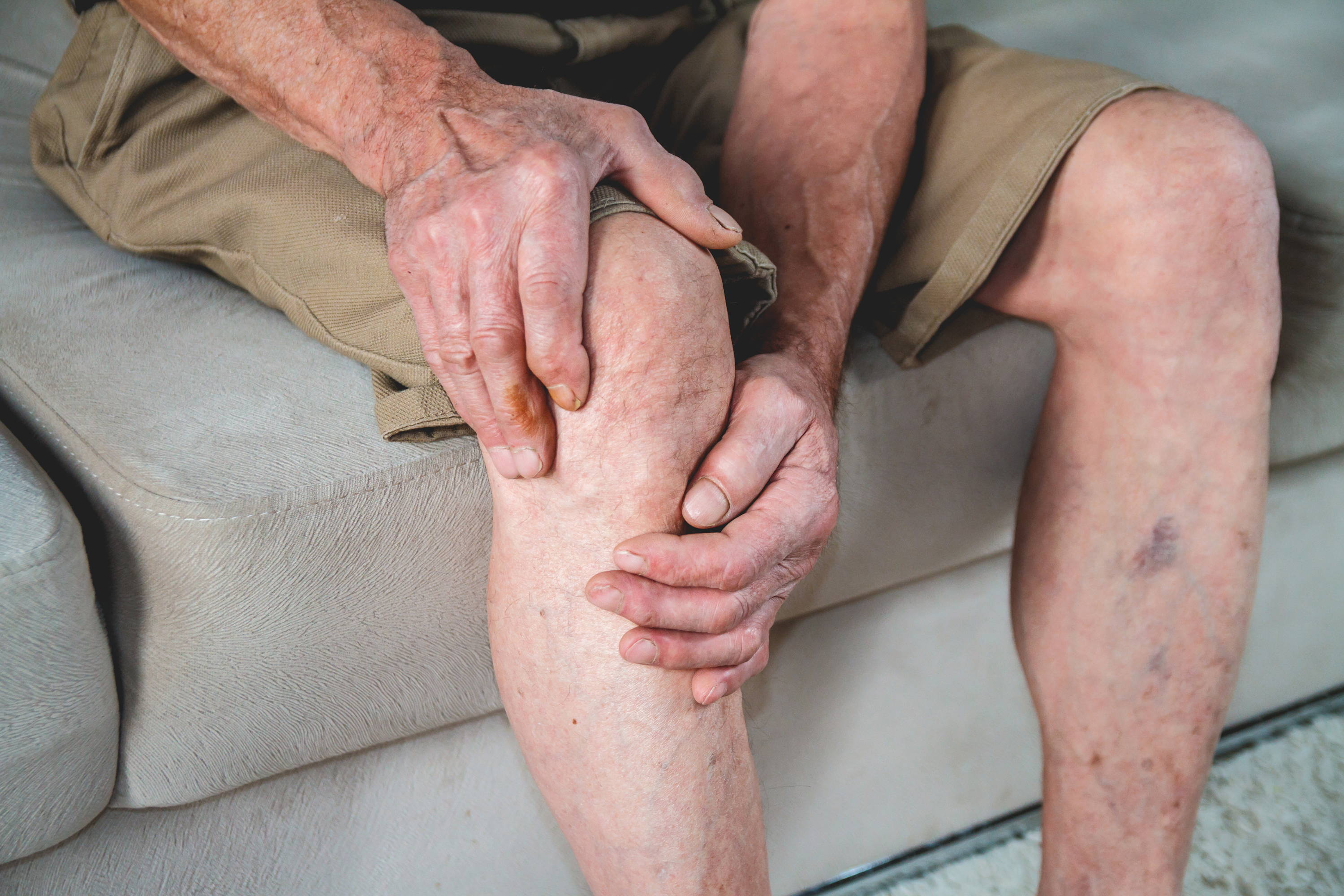 Man grabbing knee area in pain
