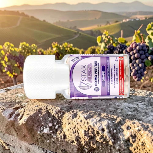 Bottle of supplement in vineyard setting with grapes and mountains in background.