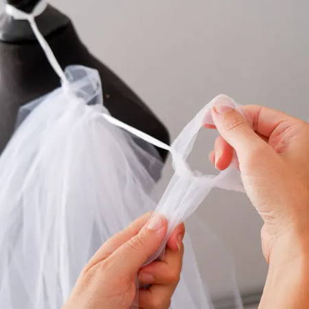 Two hands showing how to make the knots for the tutu skirt