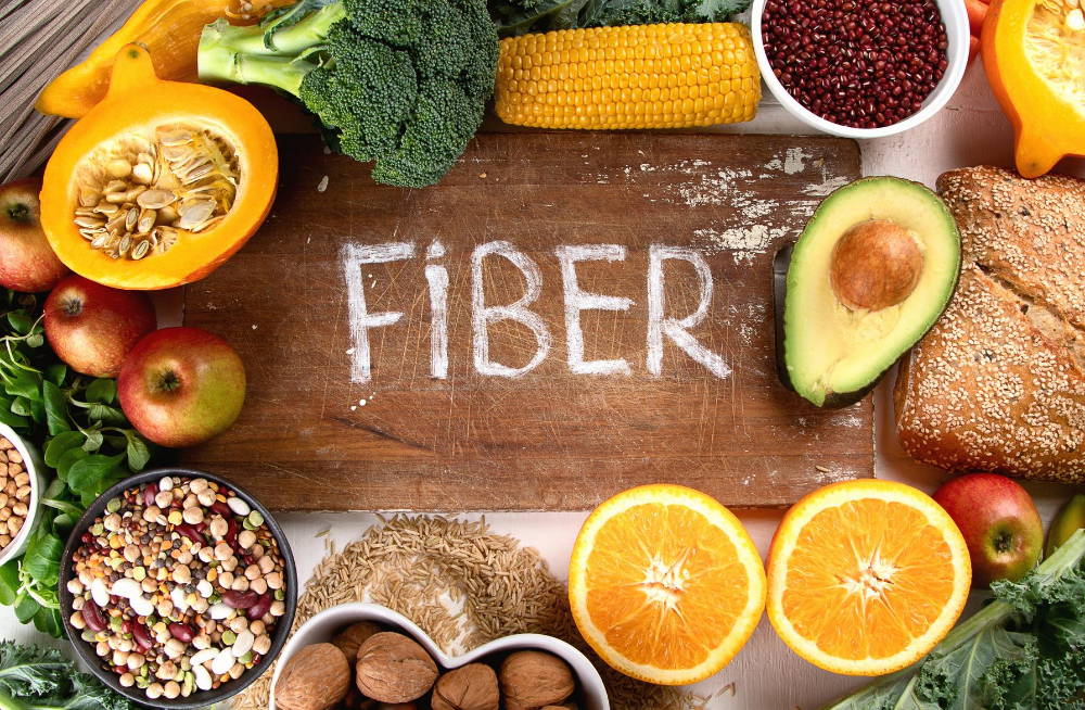 high fiber foods on a wooden table word fiber|benefits of a high fiber diet